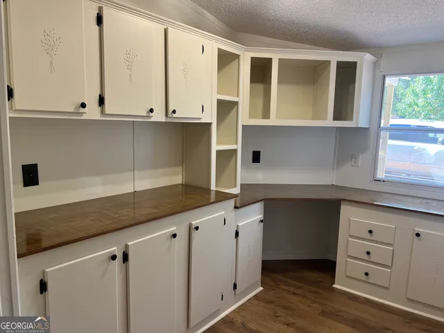 a view of hallway with closet and wooden floor