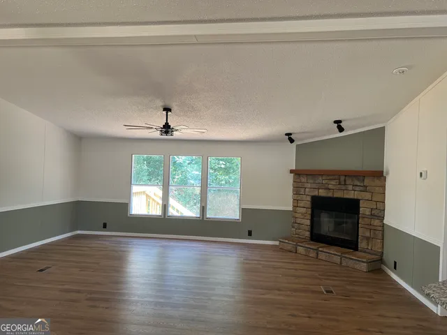 a view of empty room with wooden floor and fireplace