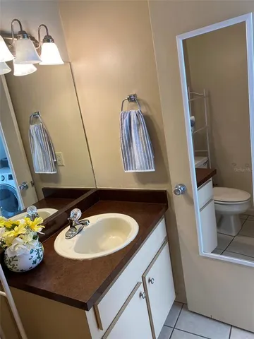 a bathroom with a sink toilet and a mirror