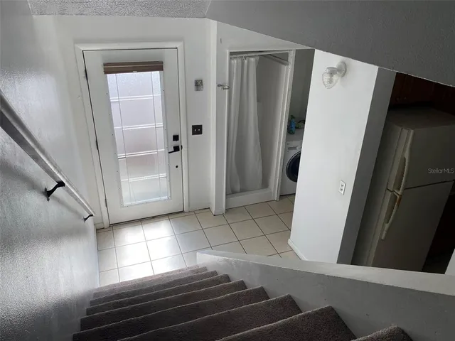 a view of a hallway with wooden floors and stairs