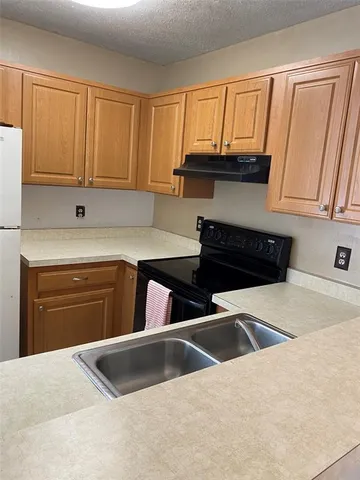 a kitchen with granite countertop a sink and a stove top oven