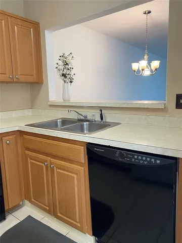 a view of a kitchen sink and dishwasher with wooden floor