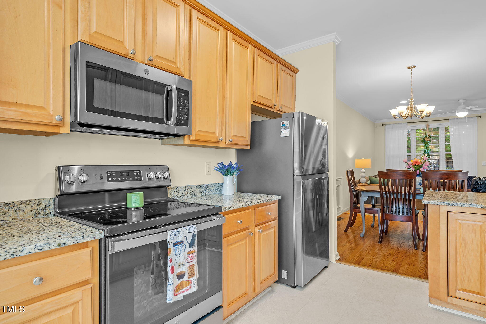 4 Scottish Lane Durham, NC 27707 - Photo 10 of 49 a kitchen with stainless steel appliances granite countertop a stove a microwave a refrigerator a dining table and chairs with wooden floor