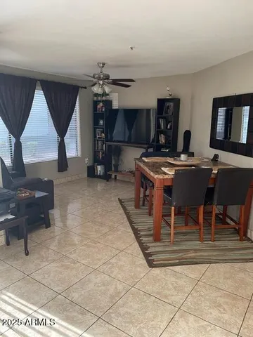 a living room with furniture a flat screen tv and kitchen view