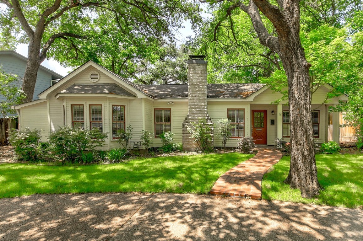 a front view of a house with a yard and potted plants