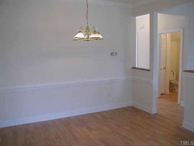 4225 Standing Rock Way Raleigh, NC 27604 - Photo 4 of 8 a view of empty room with wooden floor and chandelier