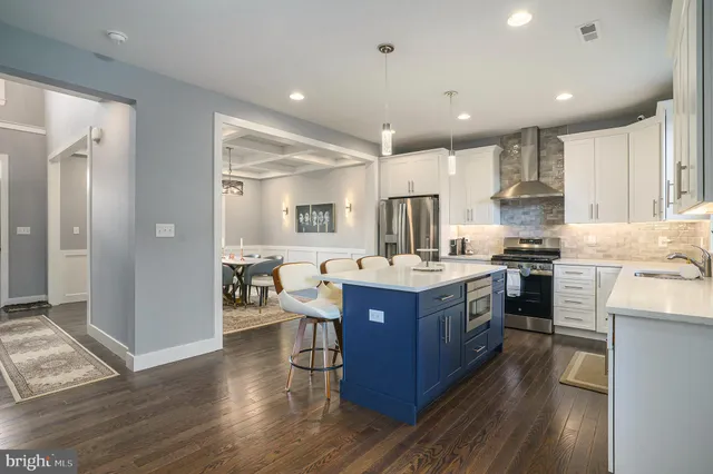 a kitchen with kitchen island granite countertop wooden floors and stainless steel appliances