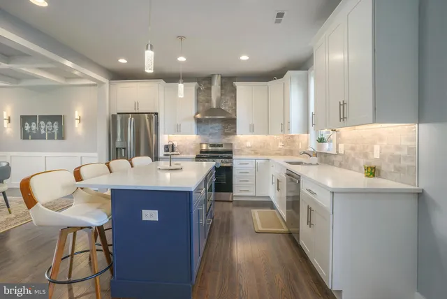 a kitchen with kitchen island granite countertop a sink a counter top space stainless steel appliances and cabinets