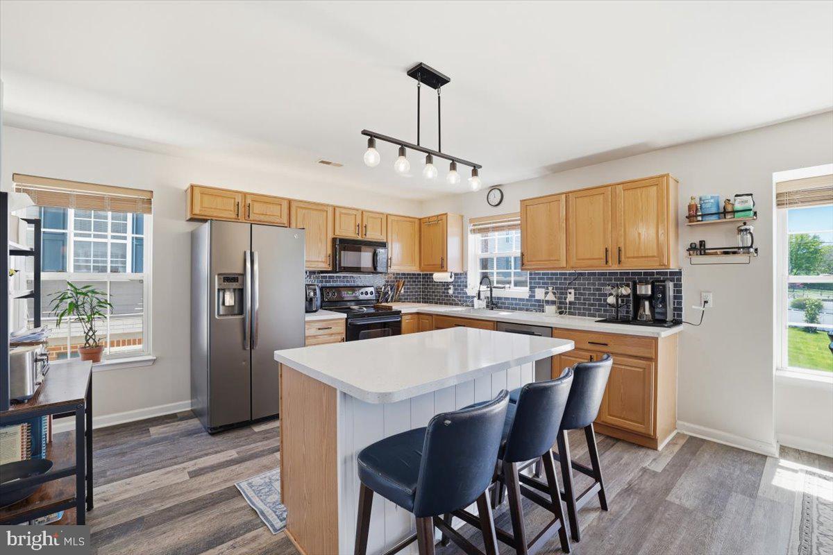 215 Birch Street Walnutport, PA 18088 - Photo 21 of 48 a kitchen with stainless steel appliances a dining table chairs refrigerator and cabinets