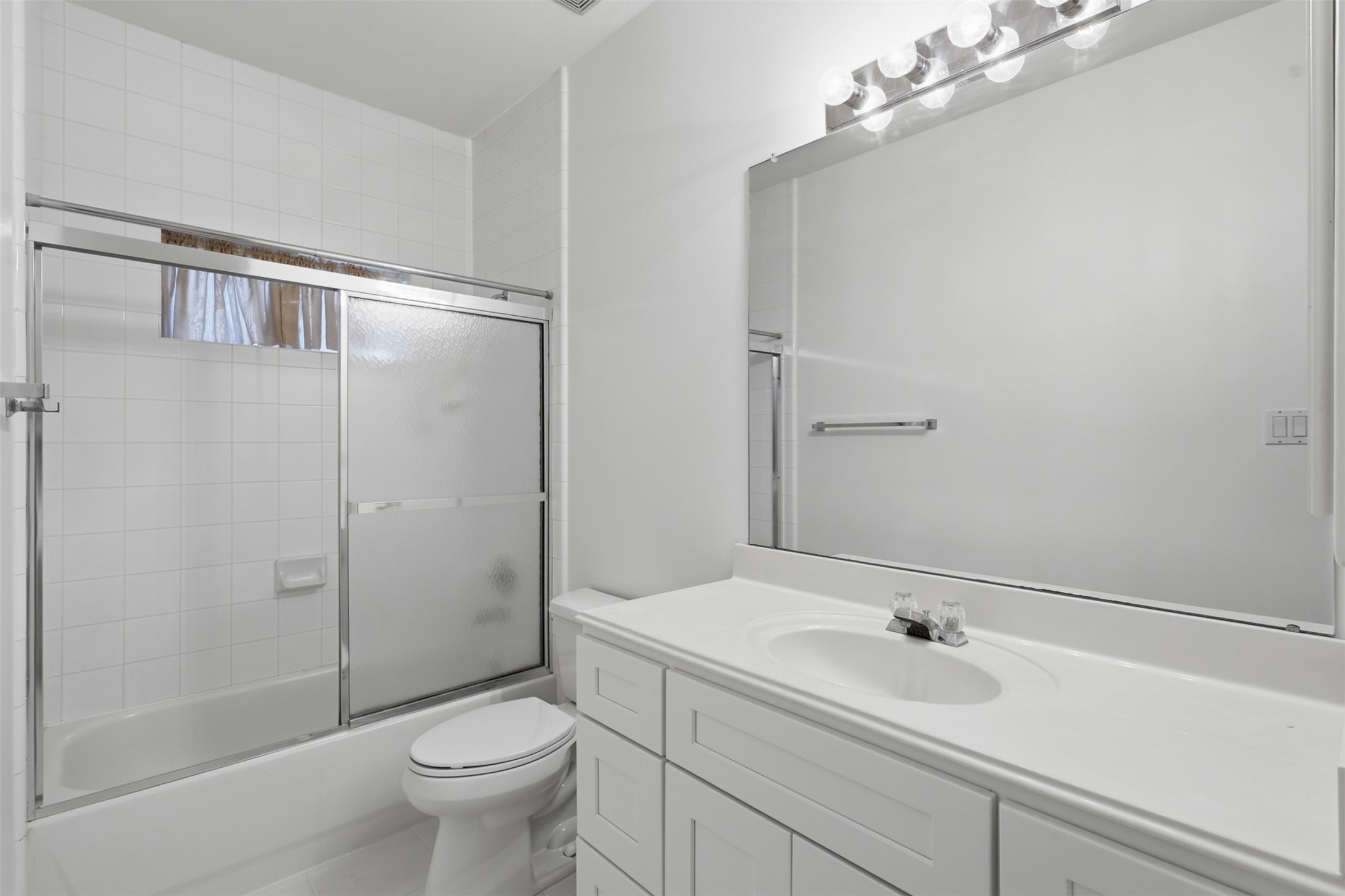 5815 Pheasant Ridge Lane Houston, TX 77041 - Photo 9 of 43 The private mother-in-law suite bathroom features durable tile flooring, a large vanity with beautiful white shaker cabinetry, and an abundance of cabinets and drawers to meet all your storage needs. The spacious layout provides both functionality and comfort, while the shower and tub combination offers the perfect space to relax and unwind after a long day.
