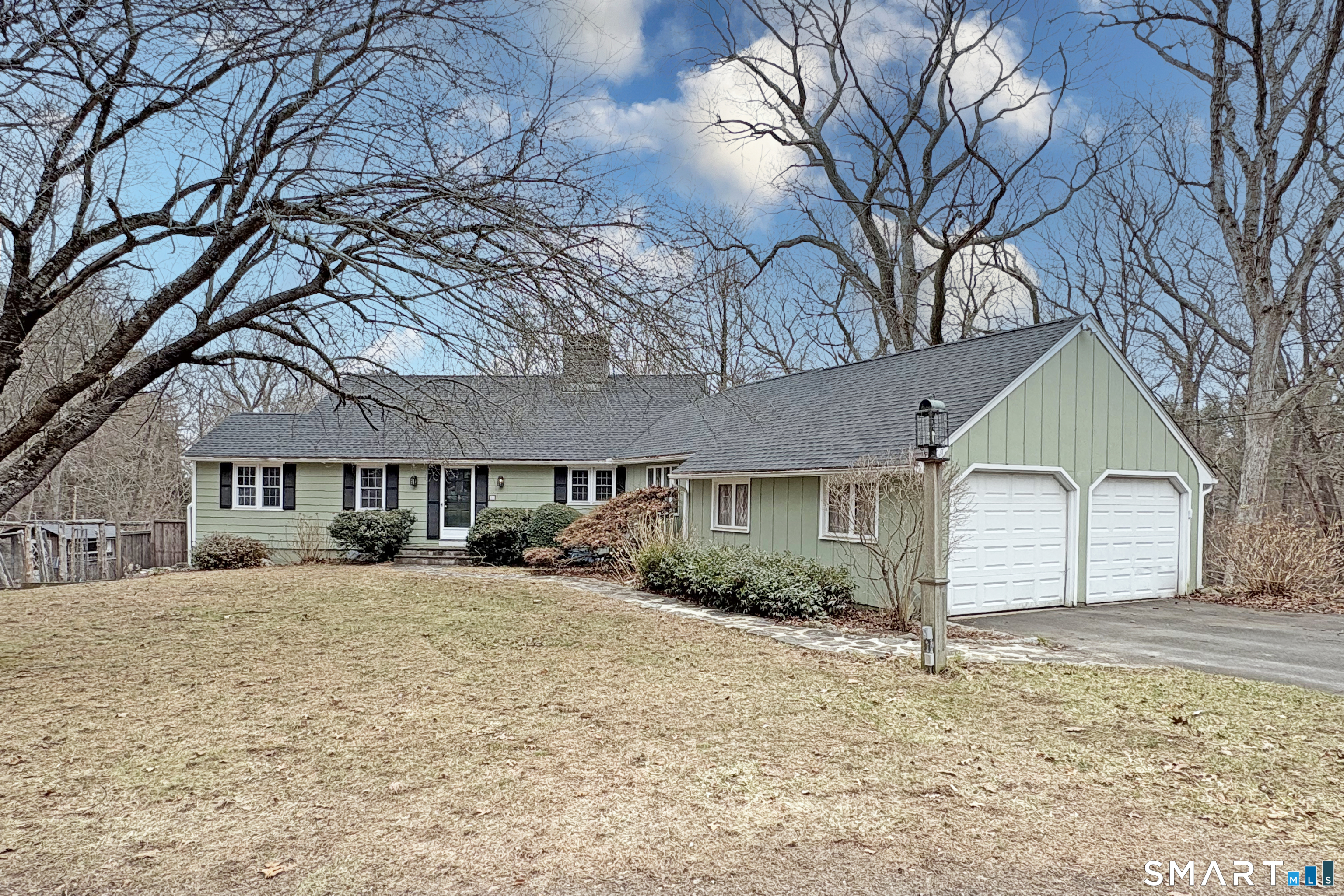 a front view of a house with a yard covered in snow