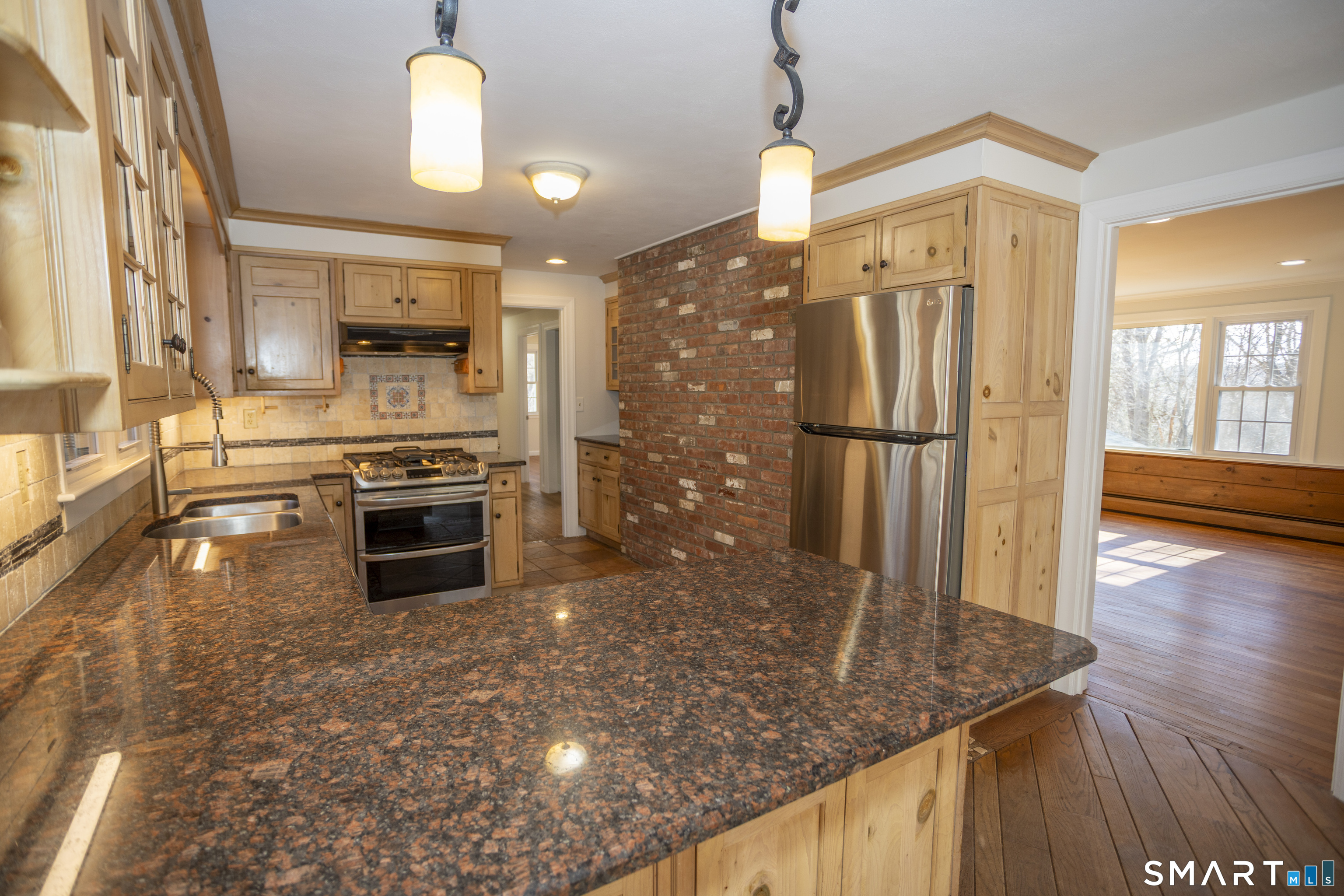 10 Cove Hill Road Essex, CT 06426 - Photo 17 of 38 a kitchen with stainless steel appliances granite countertop a refrigerator a stove and a sink with wooden floor