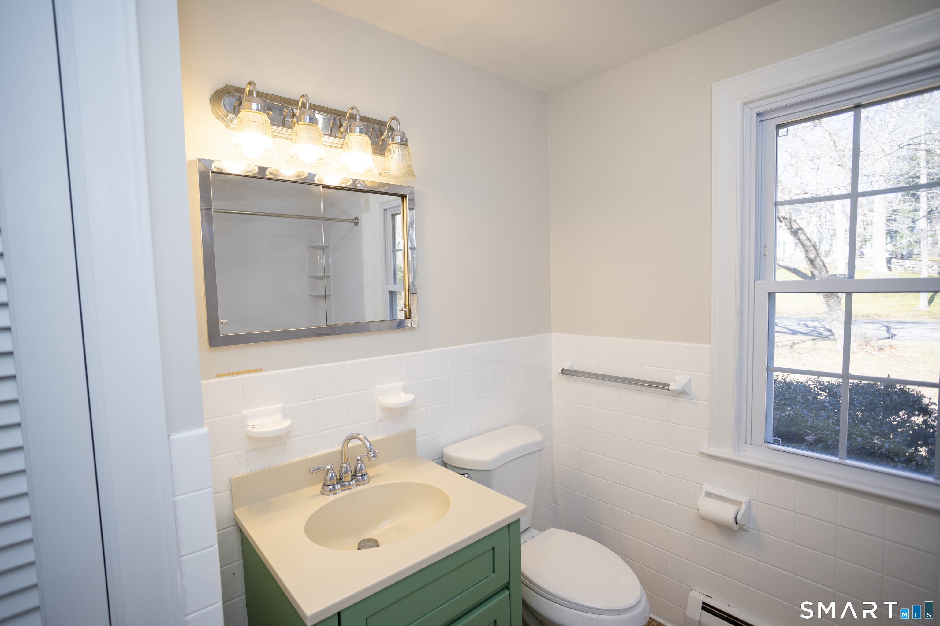 10 Cove Hill Road Essex, CT 06426 - Photo 35 of 38 a bathroom with a sink toilet a mirror and window