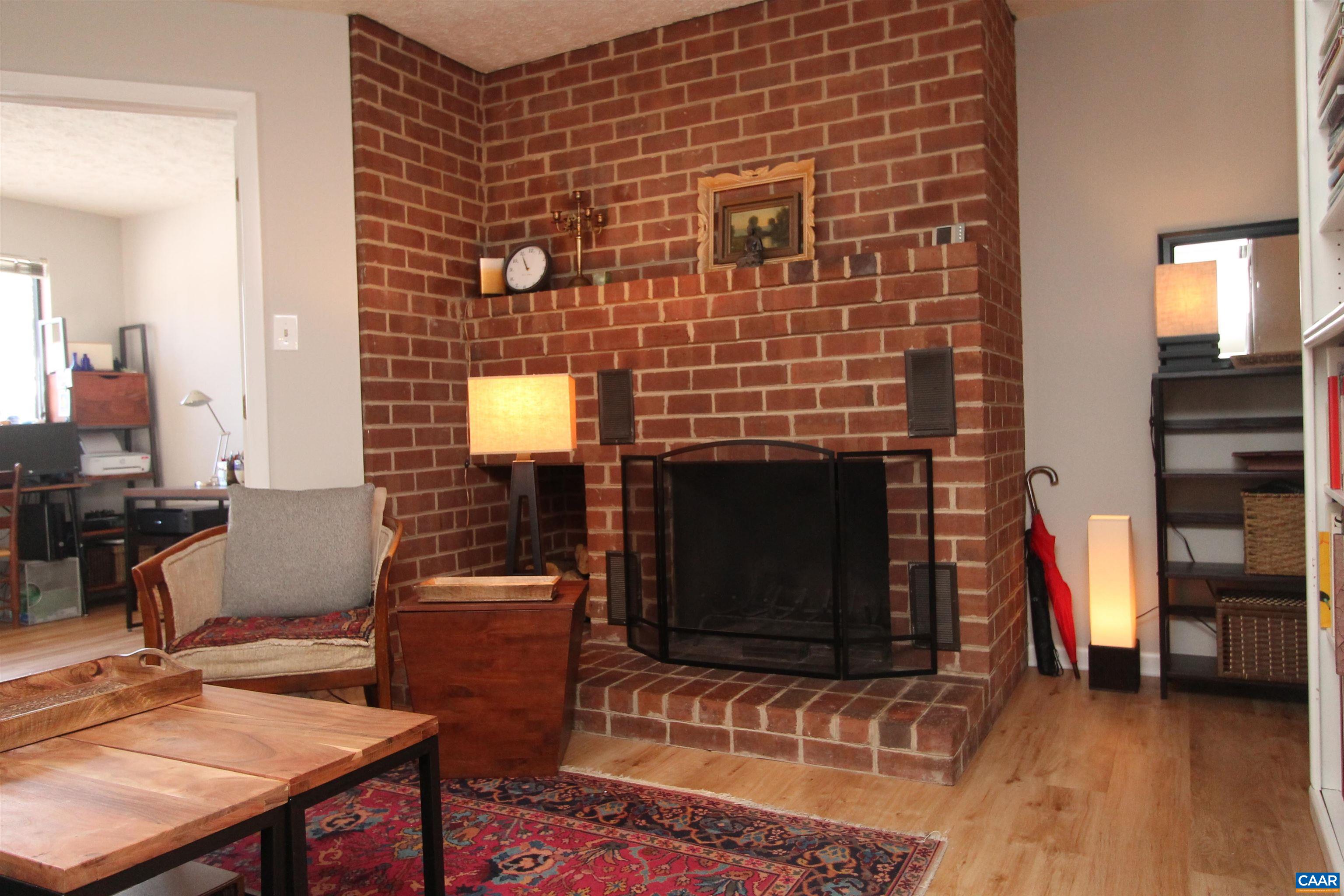 130 Turtle Creek Road, Unit 2 Charlottesville, VA 22901 - Photo 8 of 10 a brick fireplace with a table and chairs in it