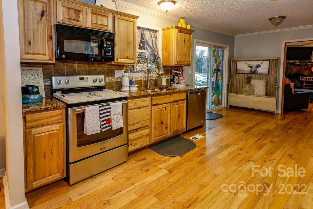 890 Rock Road Rutherfordton, NC 28139 - Photo 11 of 40 a kitchen with stainless steel appliances granite countertop a stove a sink and a microwave