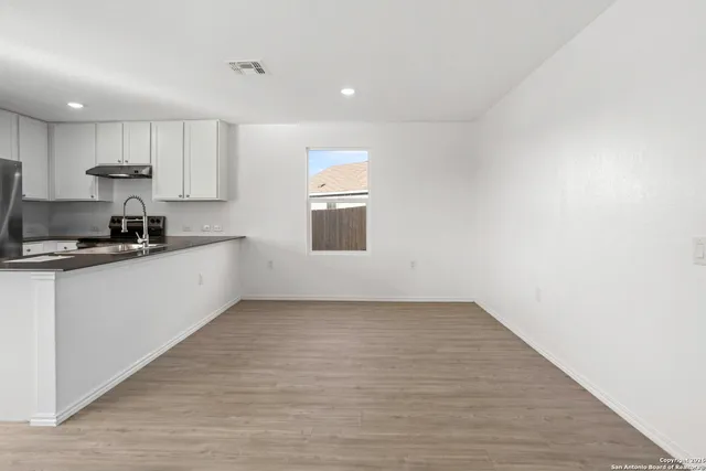 a kitchen with a sink a refrigerator and cabinets