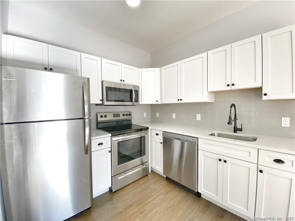 a kitchen with cabinets stainless steel appliances a sink and a center island