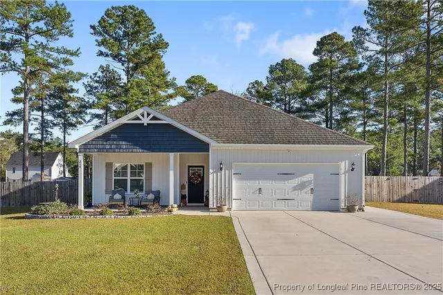 a view of a house with a yard and large tree