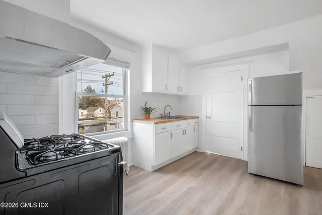 a kitchen with a stove a refrigerator and a wooden floor