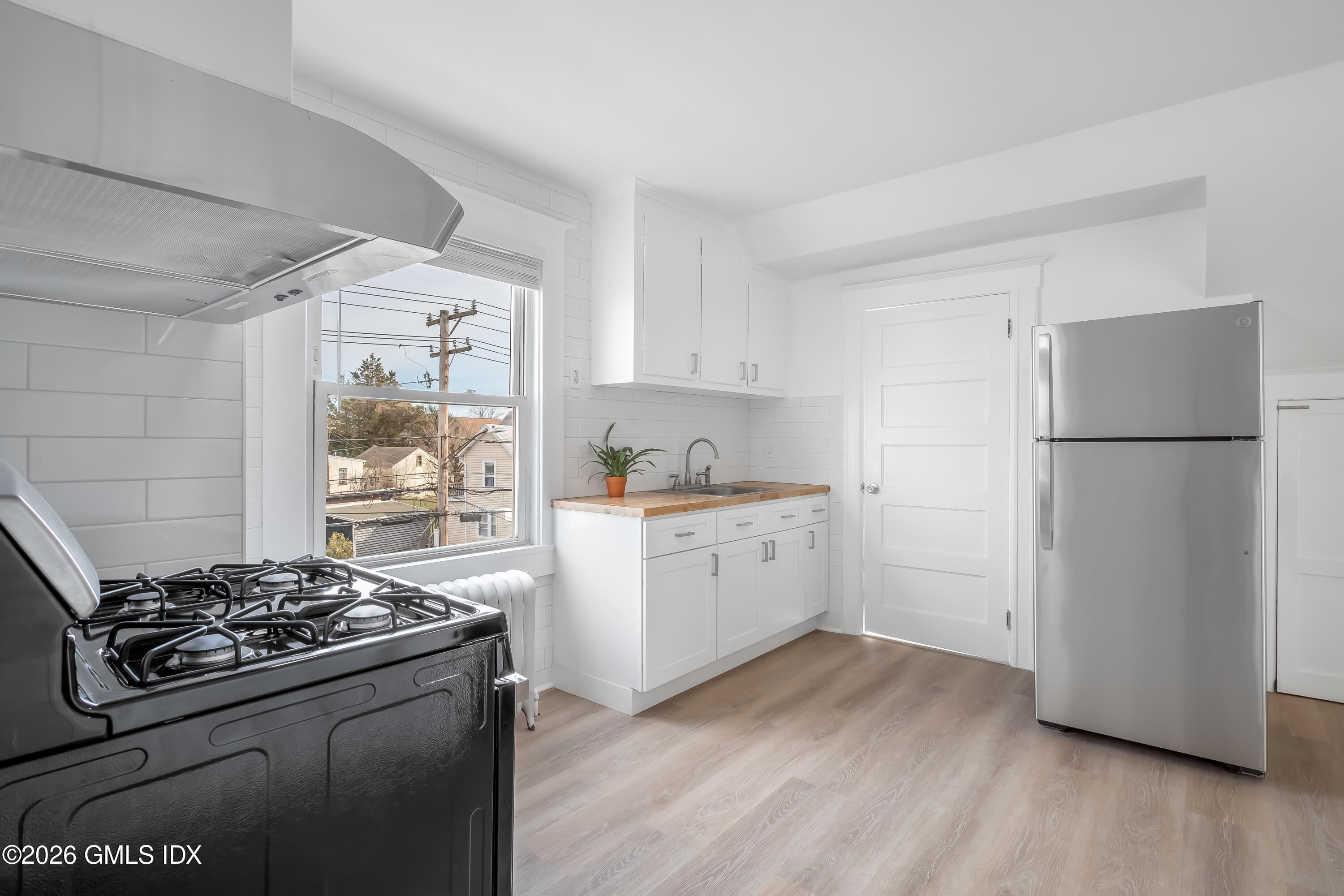 a kitchen with a stove a refrigerator and a wooden floor