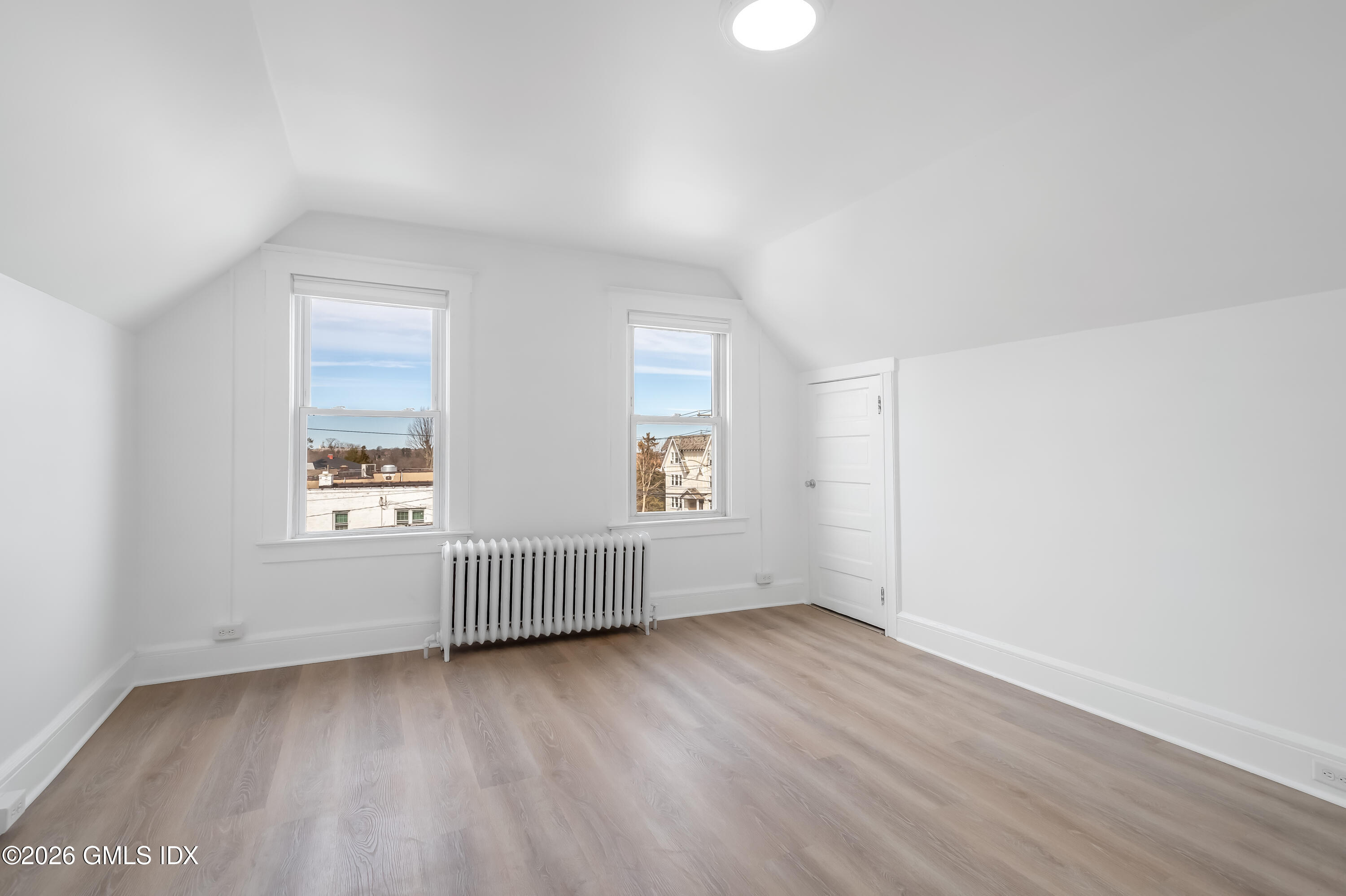 140 Hamilton Avenue, Unit 3 Greenwich, CT 06830 - Photo 4 of 11 an empty room with wooden floor and windows