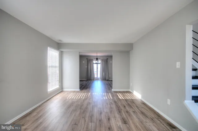 a view of a room with wooden floor chandelier and a ceiling fan
