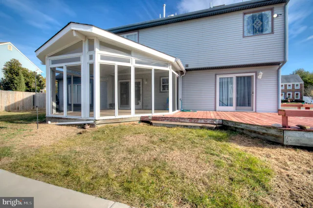 a view of an empty room with wooden floor and window
