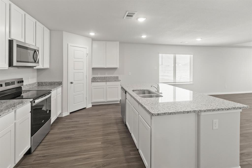 10024 Freighter Trail Fort Worth, TX 76131 - Photo 2 of 14 a kitchen with stainless steel appliances granite countertop a stove a sink and a refrigerator