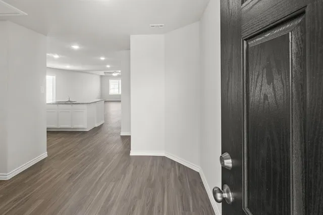 a walk in closet with wooden floor