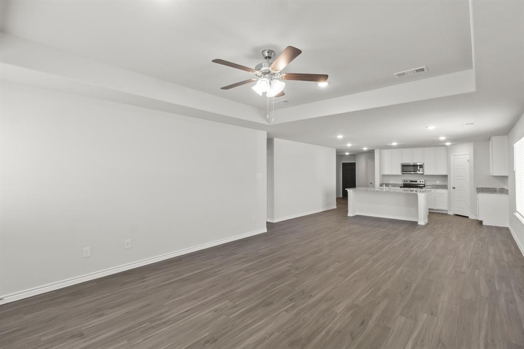 10024 Freighter Trail Fort Worth, TX 76131 - Photo 5 of 14 a view of an empty room with wooden floor and a ceiling fan