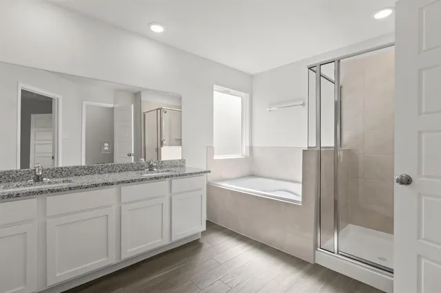 a bathroom with a granite countertop bathtub a sink and a shower