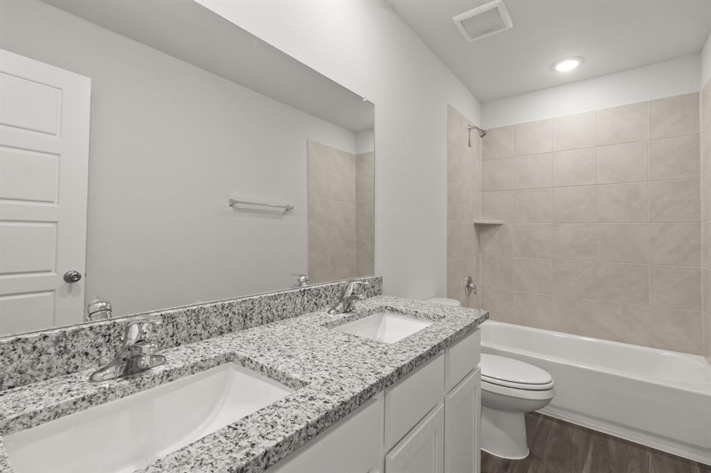 10024 Freighter Trail Fort Worth, TX 76131 - Photo 10 of 14 a bathroom with a granite countertop sink a toilet and shower