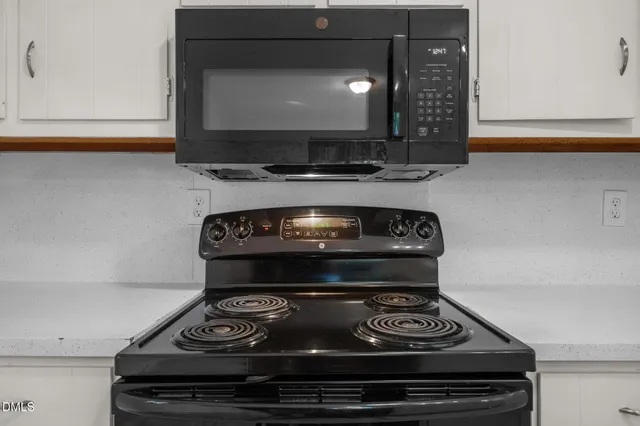 a stove top oven sitting inside of a kitchen