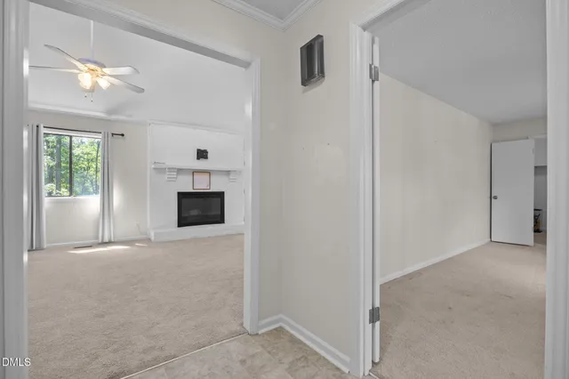 a view of a livingroom with an empty space & a window