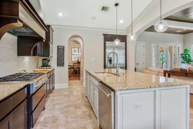a kitchen with a granite countertop sink and cabinets