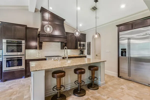a kitchen with stainless steel appliances granite countertop a stove and a refrigerator
