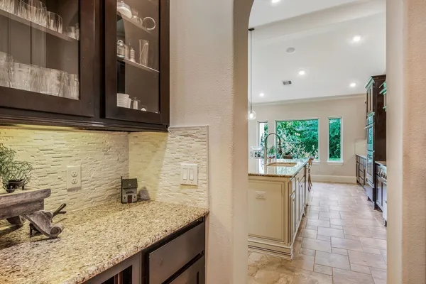 a kitchen with a granite countertop sink and cabinets