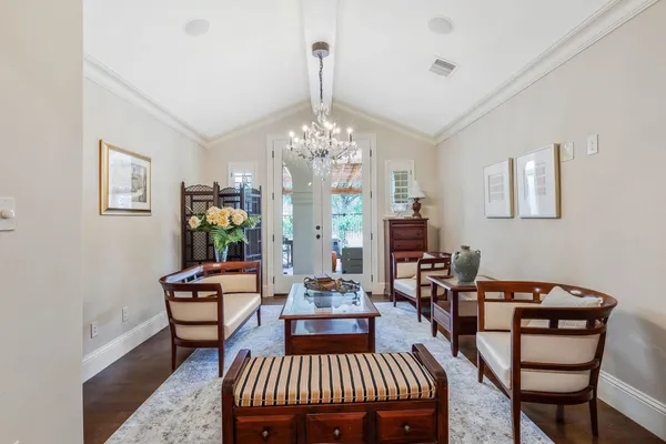 a living room with furniture a chandelier and a dining table