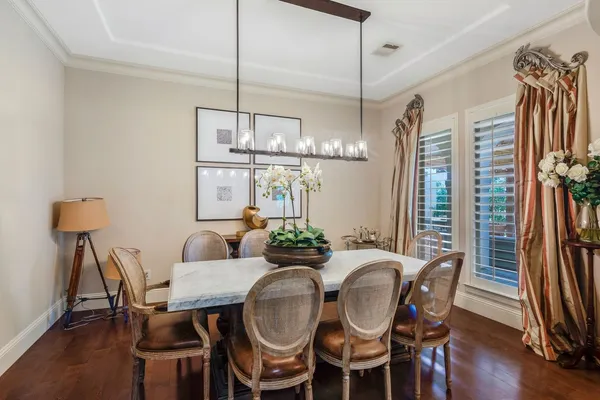 a dining room with furniture a chandelier and wooden floor