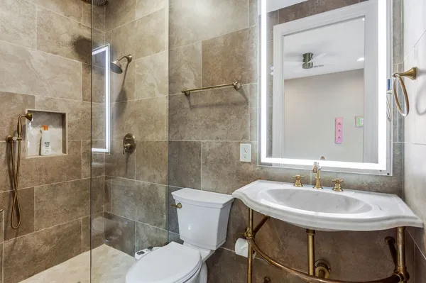 a bathroom with a sink toilet and shower