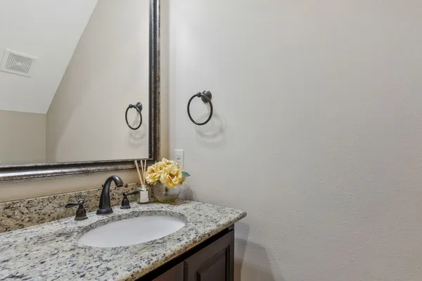a bathroom with a granite countertop sink and a mirror