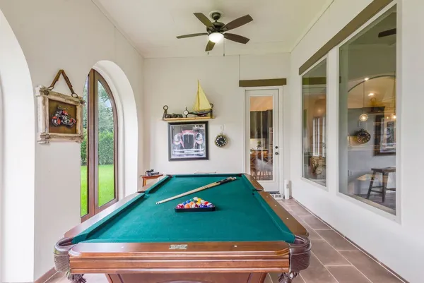 a room with pool table and windows