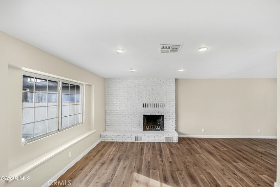 45503 11th Street West Lancaster, CA 93534 - Photo 3 of 37 an empty room with wooden floor and a fireplace