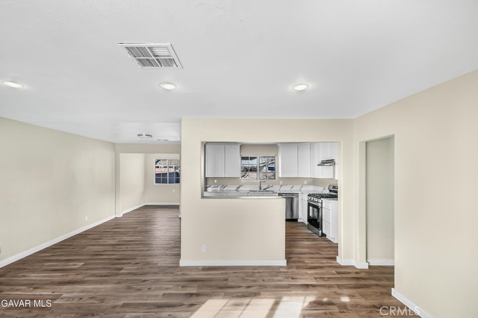 45503 11th Street West Lancaster, CA 93534 - Photo 5 of 37 a living room with stainless steel appliances kitchen island granite countertop a refrigerator cabinets and wooden floor
