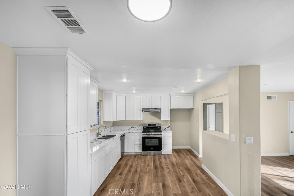 45503 11th Street West Lancaster, CA 93534 - Photo 7 of 37 a kitchen with a refrigerator a oven and a sink