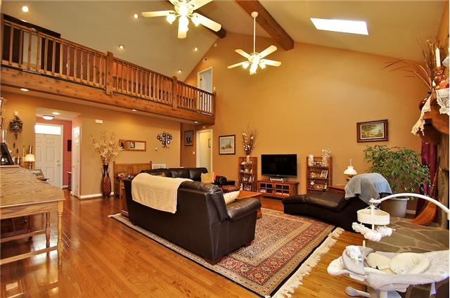 1125 Lewis Road Burns, TN 37029 - Photo 10 of 20 Large open living room with hardwood floors, sky lights & access to screened patio. Stone fireplace has gas logs or can be used as a wood burning fireplace