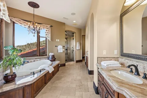 a spacious bathroom with a double vanity sink a large mirror and a bathtub