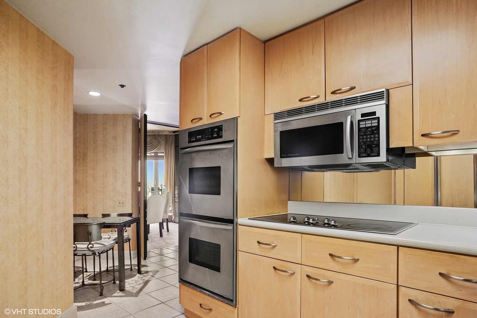 950 North Michigan Avenue, Unit 2203 Chicago, IL 60611 - Photo 18 of 26 a kitchen with stainless steel appliances a stove a microwave and a sink