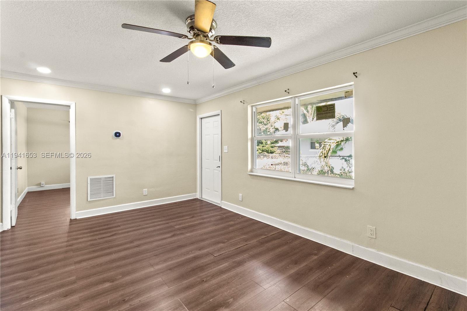 441 Northeast 30th Street, Unit 12 Pompano Beach, FL 33064 - Photo 12 of 33 a view of an empty room with wooden floor and a window