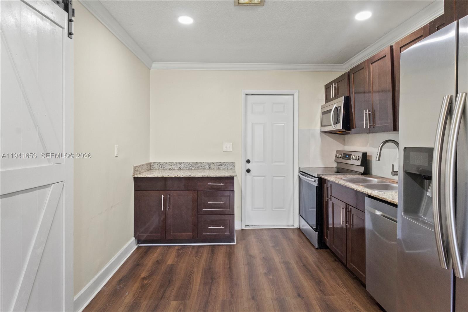 441 Northeast 30th Street, Unit 12 Pompano Beach, FL 33064 - Photo 13 of 33 a kitchen with stainless steel appliances granite countertop a stove a sink and a refrigerator